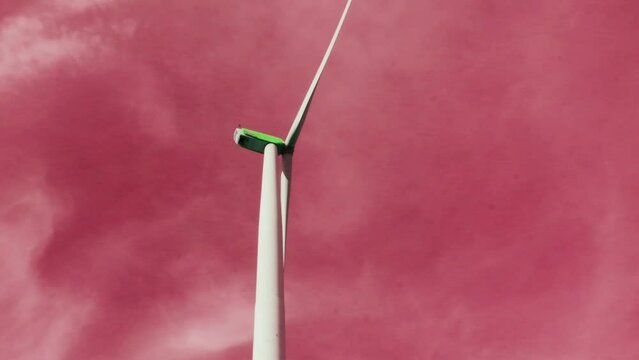 Wind Energy Dreams.Wind generator in pink clouds. Wind power through rose-colored glasses.Alternative green energy. Illusions and disappointed expectations of wind energy. 4k footage