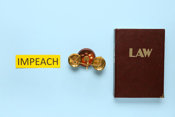 Word IMPEACH with scales of justice and law book on blue background