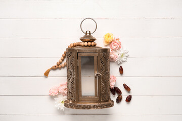 Muslim lamp with flowers, tasbih and dates on white wooden background. Ramadan celebration