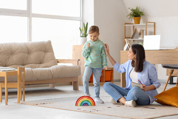 Female psychologist working with angry little girl in office