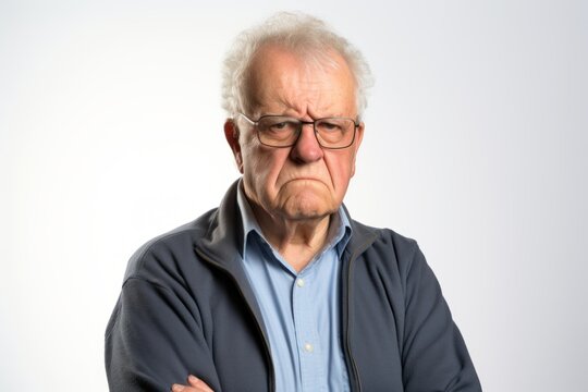 Elderly man with a serious expression on his face on grey background