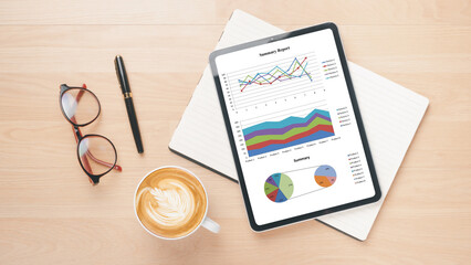 Analytical workspace featuring a tablet with summary graphs, flanked by financial papers, elegant...