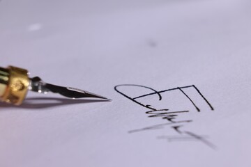 Fountain pen and signature on sheet of paper, closeup