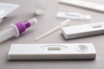Disposable express test kits on grey background, closeup