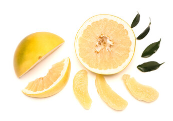 Cut tasty pomelo fruit and leaves on white background