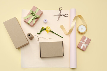 Gift boxes with wrapping paper and beautiful flower on yellow background. International Women's Day