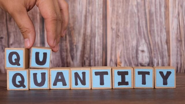 Choose quality over quantity concept. Wooden blocks word typography.