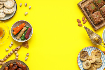 Composition with traditional Eastern sweets, Aladdin lamp and tasbih for Ramadan on yellow background