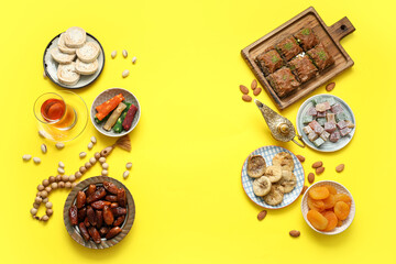 Composition with traditional Eastern sweets, Aladdin lamp and tasbih for Ramadan on yellow...