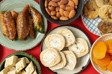 Plates with different Eastern sweets for Ramadan on red background, closeup