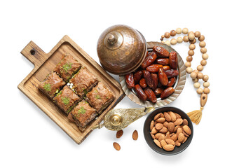 Composition with traditional Eastern sweets and tasbih for Ramadan on white background