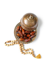 Bowl with tasty dried dates and tasbih for Ramadan on white background