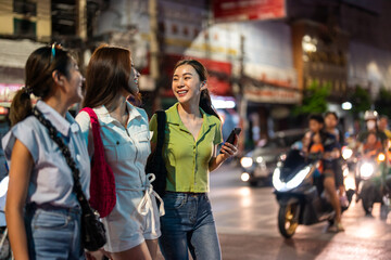 Fototapeta premium Asian beautiful women friend traveling outdoors in the city at night. 
