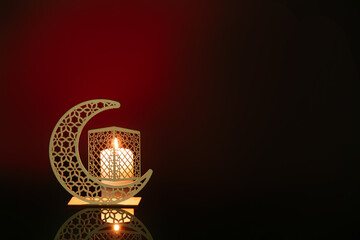 Decorative crescent with burning candle for Ramadan on dark red background