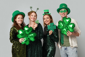 Group of people with clovers on light background. St. Patrick's Day celebration