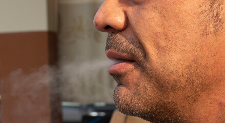 Close up man smoking a cigarette.  Cigarette smoke spread. Healthy concept. - obrazy, fototapety, plakaty
