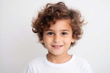 Portrait of a cute little boy with curly hair over gray background