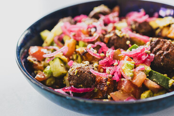 plant-based falafel nourish bowl salad with avocado tomato cucmber and pickled onion