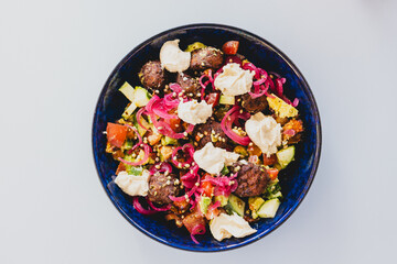 plant-based falafel nourish bowl salad with avocado tomato cucmber and pickled onion