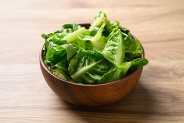 Organic cos romaine lettuce in wooden bowl, Food ingredient for healthy salad