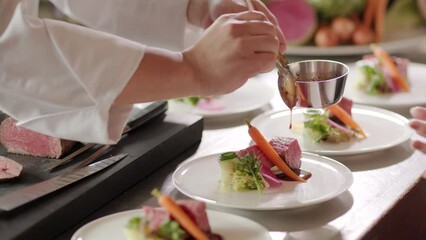 野菜の付け合わせ牛ヒレ肉のステーキにソースをかける料理人　レストラン・シェフ・牛肉