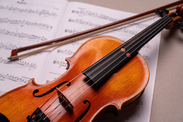 Fototapeta premium Halbe Geige mit Bogen liegt auf Notenblatt, Studioaufnahme, Deutschland