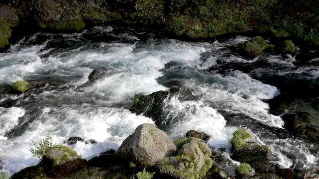 Water flows through the stones, in slow motion. Location the Daiya River in Nikko, Japan, where the gentle flow of water harmonizes with the natural beauty of the surroundings.