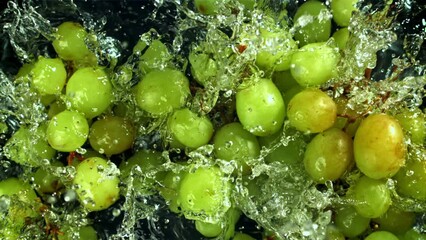 Green grapes fall with splashes into the water. Top view. Filmed on a high-speed camera at 1000 fps. High quality FullHD footage - Powered by Adobe