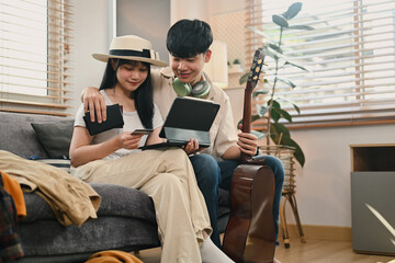 Happy young couple planning holiday trip, buy tickets, purchase flight or book hotel on digital...
