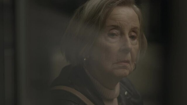 Worried Elderly Woman Waiting at Crowded Trainstation Traveling
