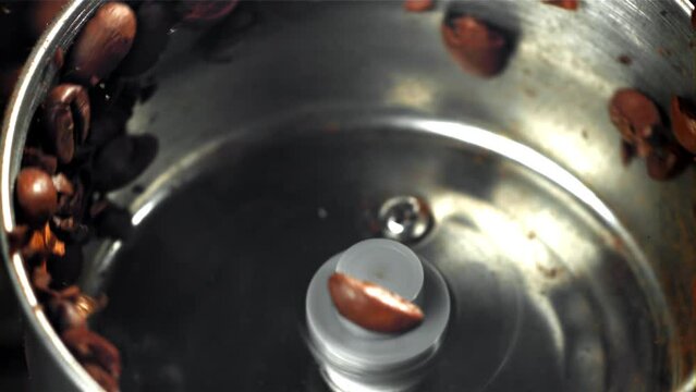 Coffee beans in a working grinder. Filmed on a high-speed camera at 1000 fps. High quality FullHD footage