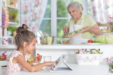 Portrait of young girl using tablet at kitchen