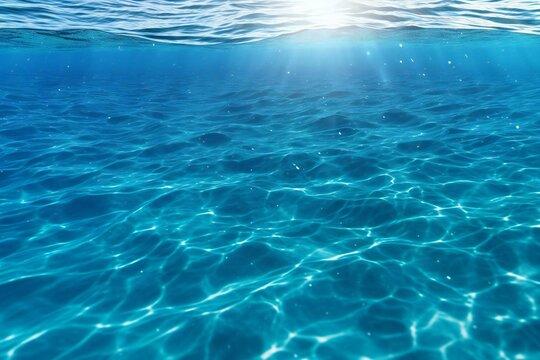 Underwater view of blue sea water surface with sun rays and lens flare
