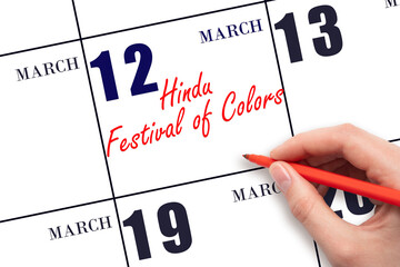 March 12. Hand writing text Hindu Festival of Colors on calendar date. Save the date.