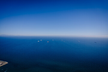 Gibraltar, Britain - January 24, 2024 - clear blue sea with several ships and a distant mountain range under a bright blue sky.
