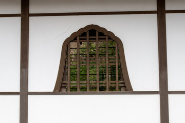 Window on white wall in Sanzen-in temple in Kyoto, Japan