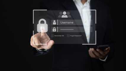 Database and system security concepts. Businessman hand touching log in virtual screen and using phone against dark background .