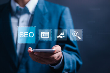 SEO concept, Businessman use smartphone with virtual SEO icons to analyze SEO search engine optimization for promoting ranking traffic on website and optimizing your website to rank in search engines.