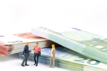 Miniature businessman navigates the financial landscape, surrounded by Euro banknotes, embodying...