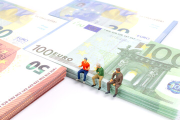 Miniature businessman navigates the financial landscape, surrounded by Euro banknotes, embodying...