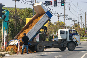 The truck dumped sand on the road at the intersection