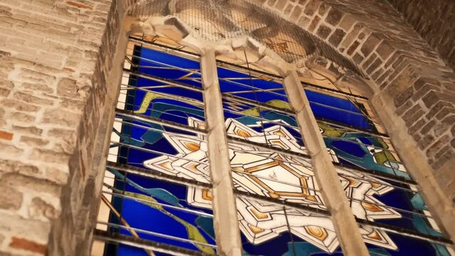 low angle view of blue stained glass window inside a gothic church at night time in Grolle the Netherlands