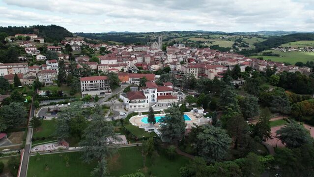 drone shot goinf forward flyng over Saint Galmier and it's church to reveal the landscape behind, loire departement, region auvergne rhone alpes, france
