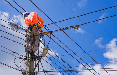 Electrician with Safety equipment and various work tools is Installing Cable lines and Electrical...