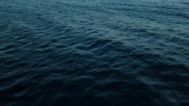 Mysterious dark blue ocean water of the deep sea with textured current ripples