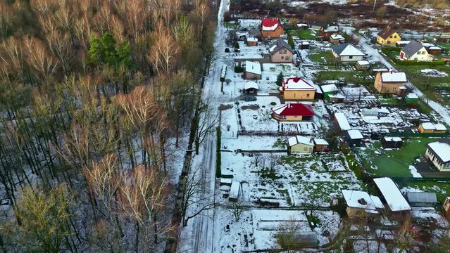Aerial drone panning shot over town houses from above with small houses covered with snow on a cold winter morning.