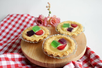 Fruit Pie served on wooden board in white background. A healthy dessert dish with cream cheese filling, garnished with strawberry and jelly.