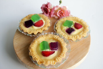 Fruit Pie served on wooden board in white background. A healthy dessert dish with cream cheese filling, garnished with strawberry and jelly.