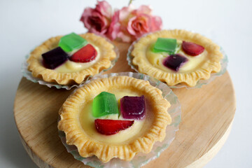 Fruit Pie served on wooden board in white background. A healthy dessert dish with cream cheese filling, garnished with strawberry and jelly.