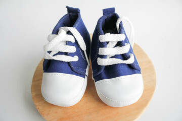 Blue baby shoes on wooden board in white background 